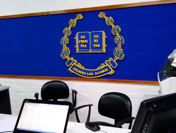 Escudo del Colegio Los Álamos, con el lema Sapientia Veritas, en la recepción del colegio