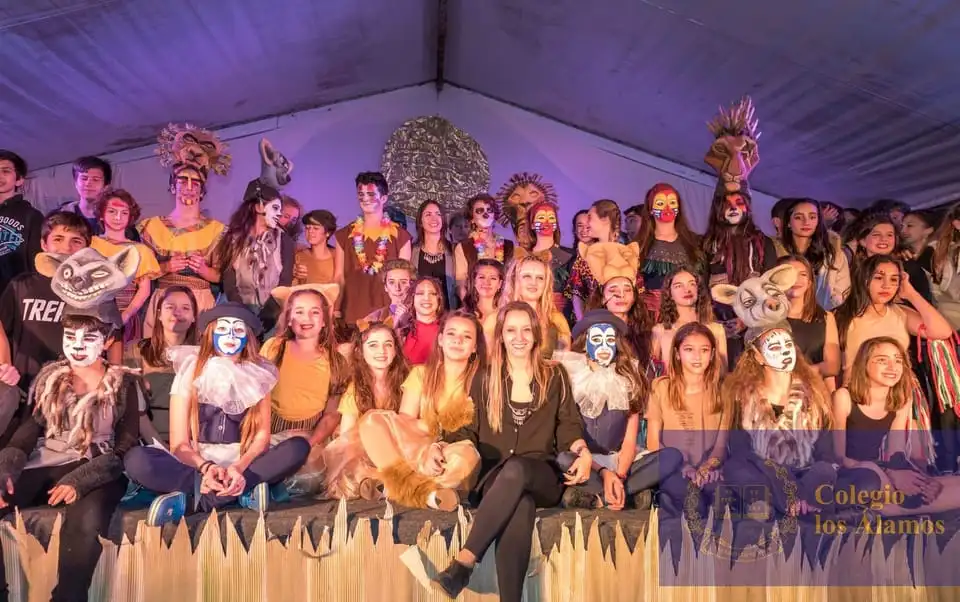 Elenco de estudiantes de secundaria caracterizados sobre el escenario en el concert anual del colegio